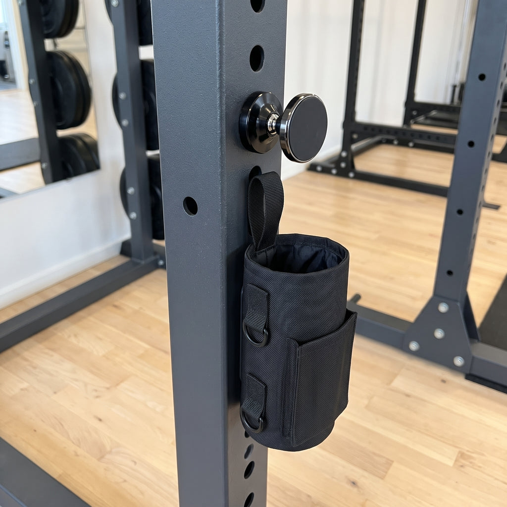 Gympaketet: svart magnetisk gymväska och svart magnetisk mobilhållare fästa på stålramen i ett gym