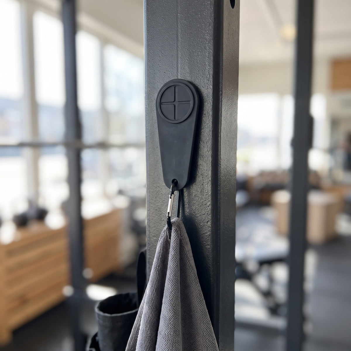 Gympaketet – den magnetiska handdukskroken fäst på maskinens stålram med en grå handduk