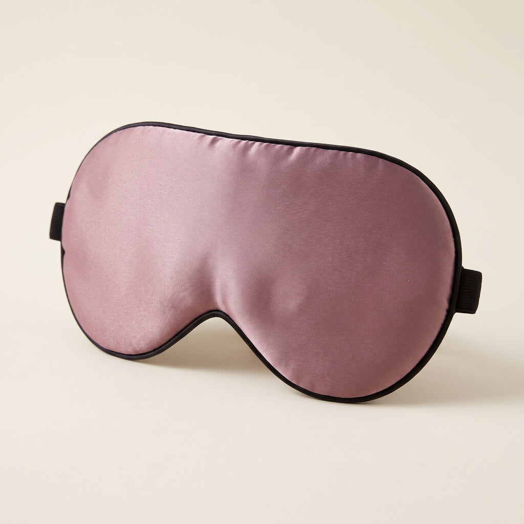 Ljusblockerande sovmask i mullbärssilke i dämpad mauve med svarta kanter, vadderade ögonkupor och justerbart svart band
